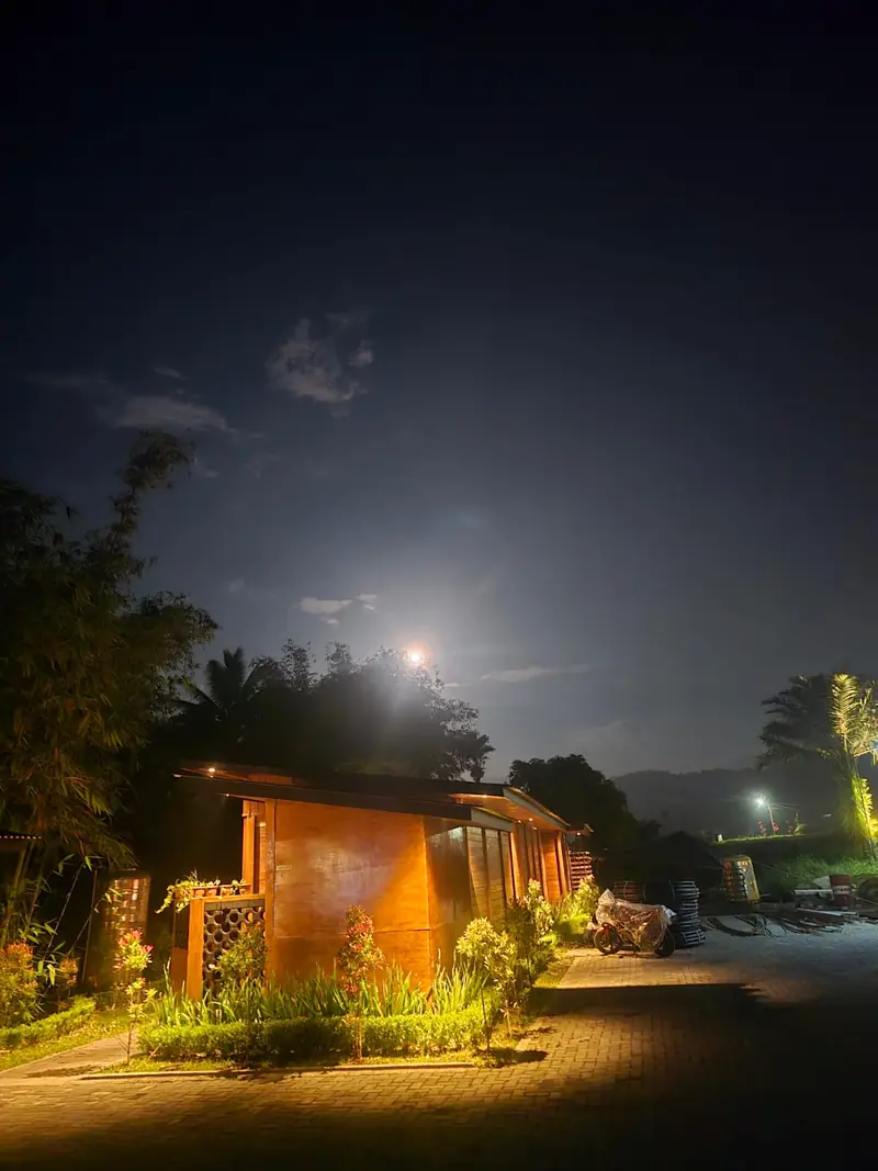 A timber villa glowing under the full moon