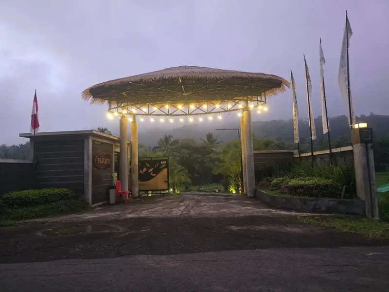 The thatched entrance gate lit at dawn
