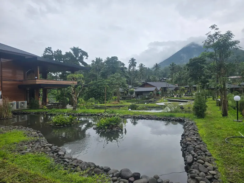 The pond, villas and Mount Lokon on a cloudy morning